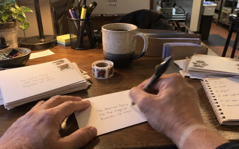 Writing thank-you cards with stamps for regular customers