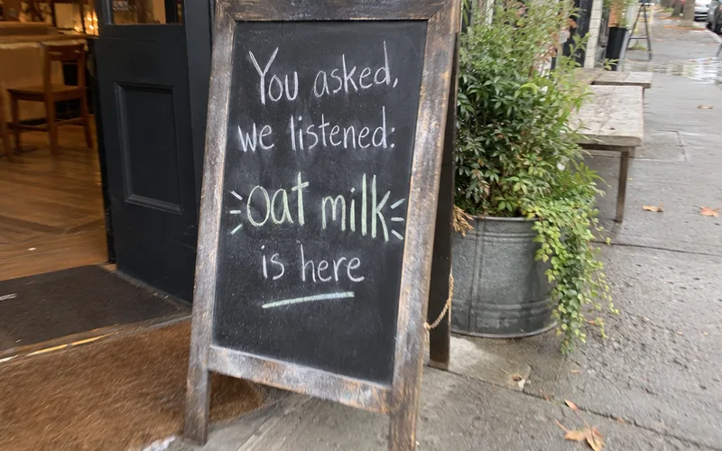 Chalkboard sign outside a cafe announcing a change made from customer feedback